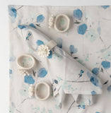 Ceramic flower napkin rings on a tea towel