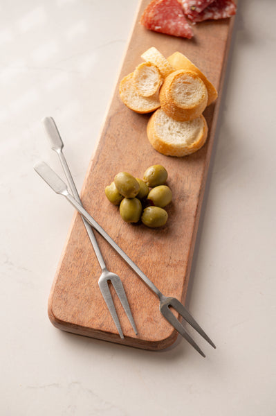 Cocktail forks on cutting board