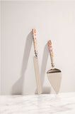 Darcy enamel cake servers against a wall