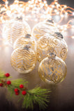 Gold Etched Glass Ornaments with lights in the background