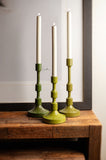 Metal taper candlestick holders on a side table. 