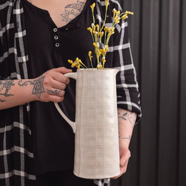 Linen mason pitcher with a flower in it