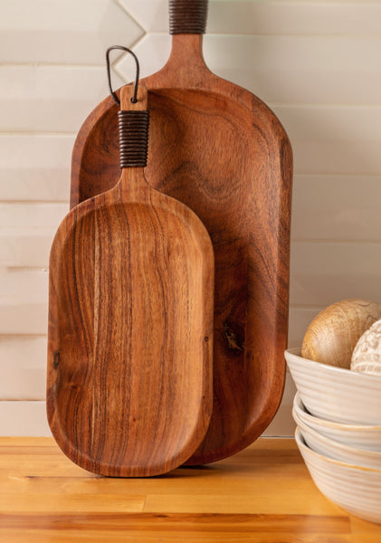 Barcelona serve boards with leather wrapped handles on a counter