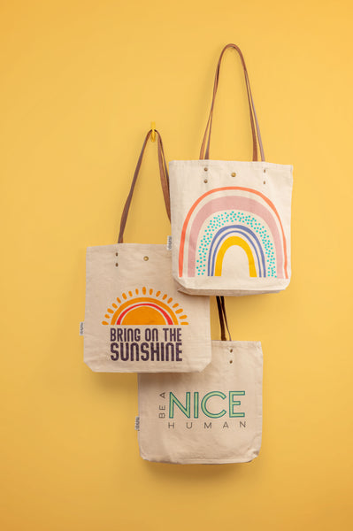 Cotton canvas book bags hanging on yellow background