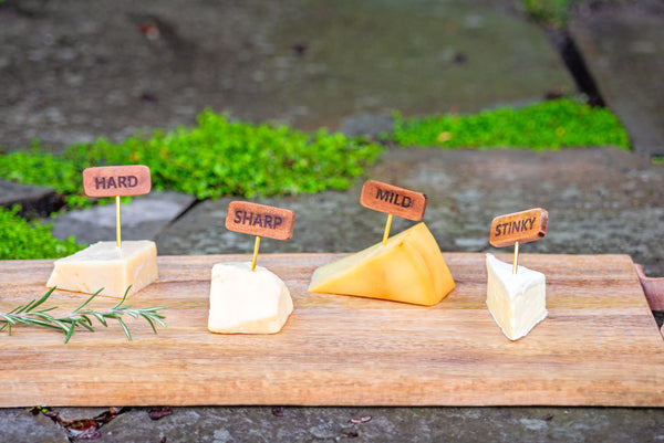 Cheese markers in cheese on a cutting board