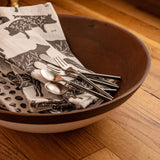 Salad bowl with tea towels and utensils inside. 