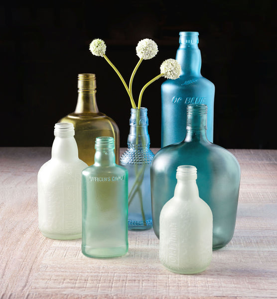 Officer's Choice Frosted Bottle on a table with other bottles. 