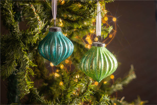Turquoise Mercury Glitter Fluted Ornament hanging from a tree