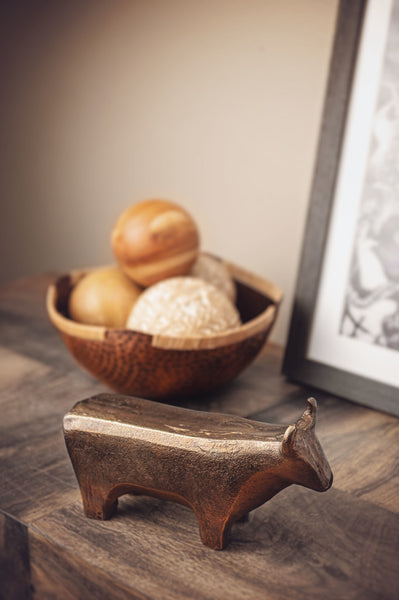 Metal cow figurine on a shelf