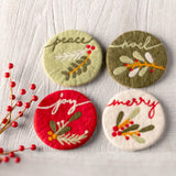 Nouveau felt coasters on a table with red berries