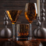 tortoiseshell glasses on a table with candles in the background