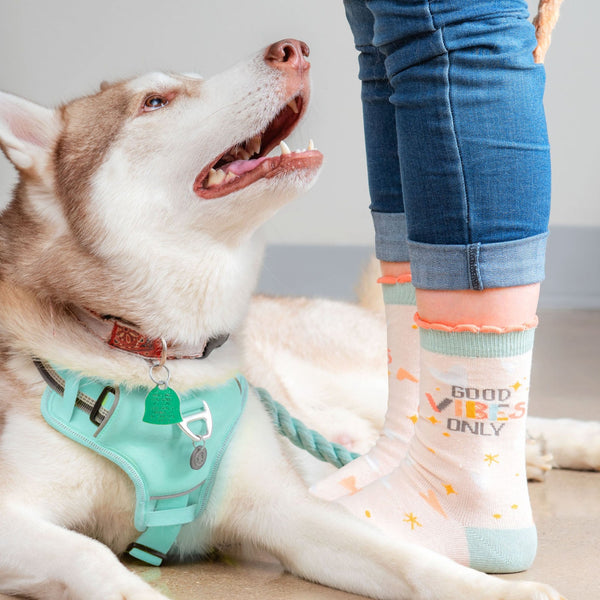 Good vibes only crew socks by a dog. 