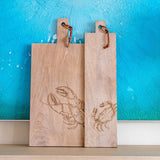 Mango wood cutting boards against a blue wall