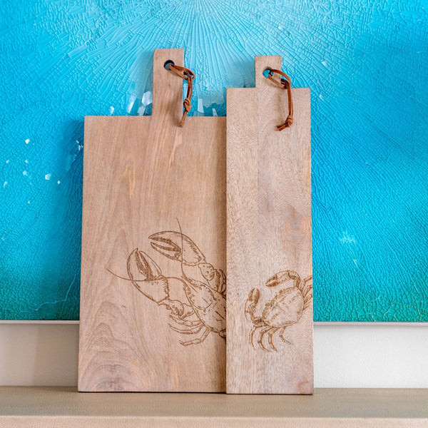 Mango wood cutting boards against a blue wall