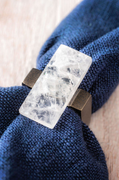 Clear rock crystal napkin ring around a blue napkin